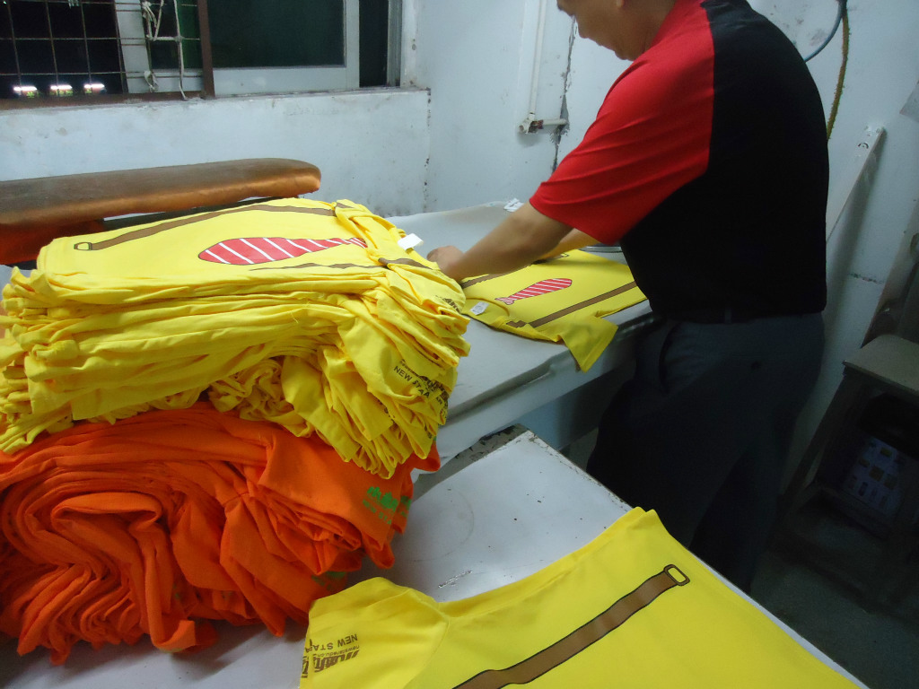 剪线翻衫后烫床开烫,如有烫钻,则压花机或者用大烫直接烫